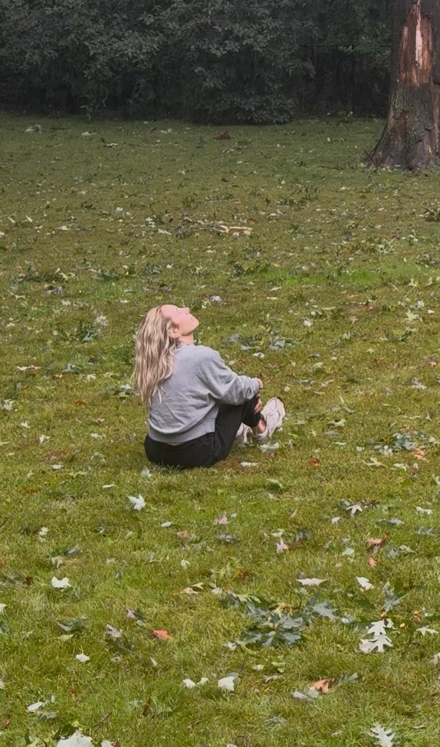 Diana sitting in the grass looking up at the sky